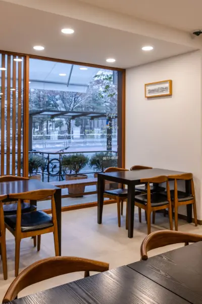 통창 뷰와 원목 가구가 어우러진 한식당 홀